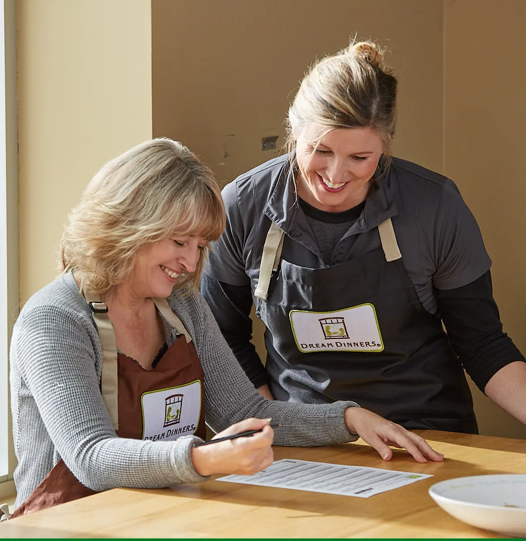 A Dream Dinners cook with a customer in the Pasadena kitchen.